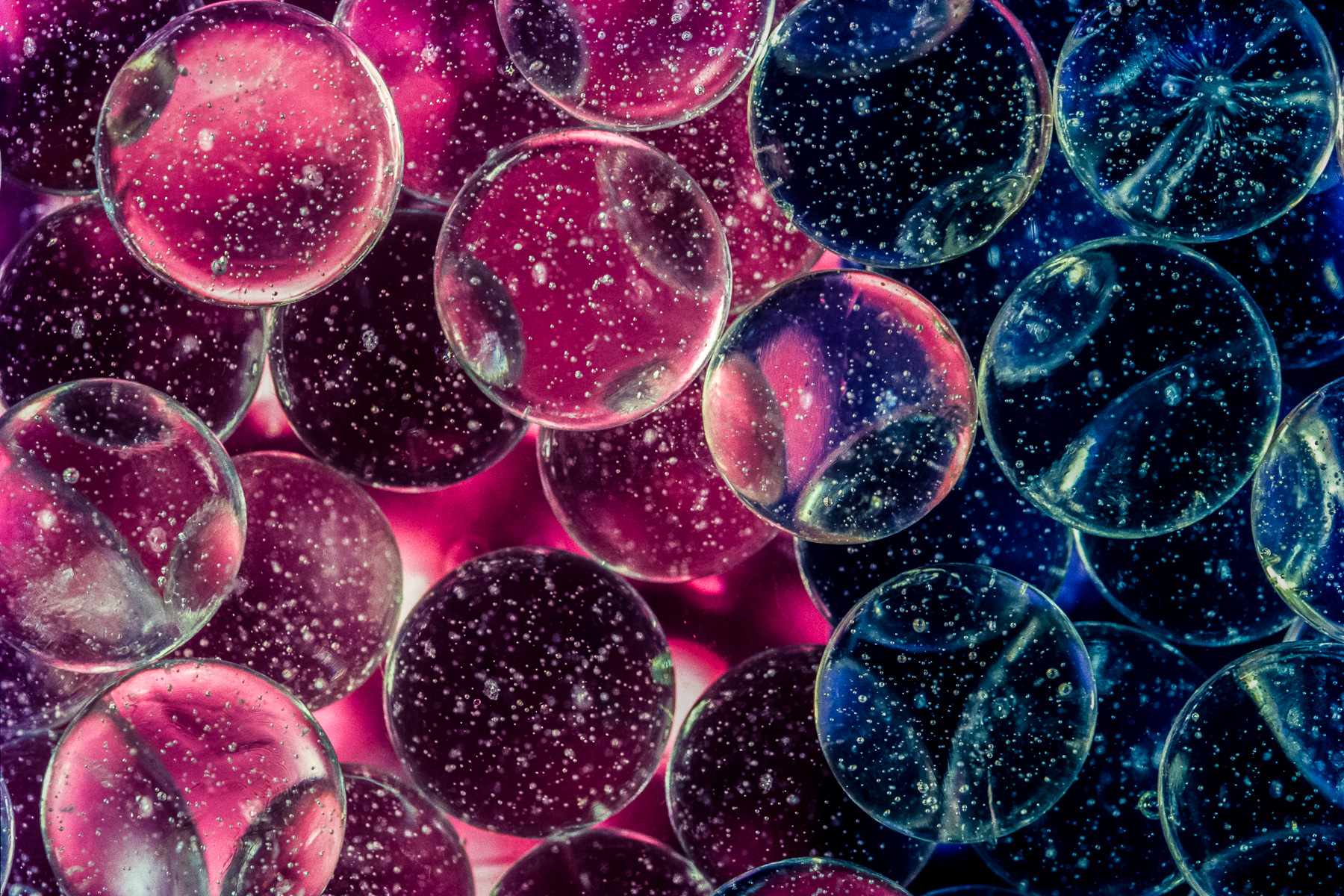 Photograph of colors filtering through glass marbles submerged in water, taken by Gil Lopez-Espina